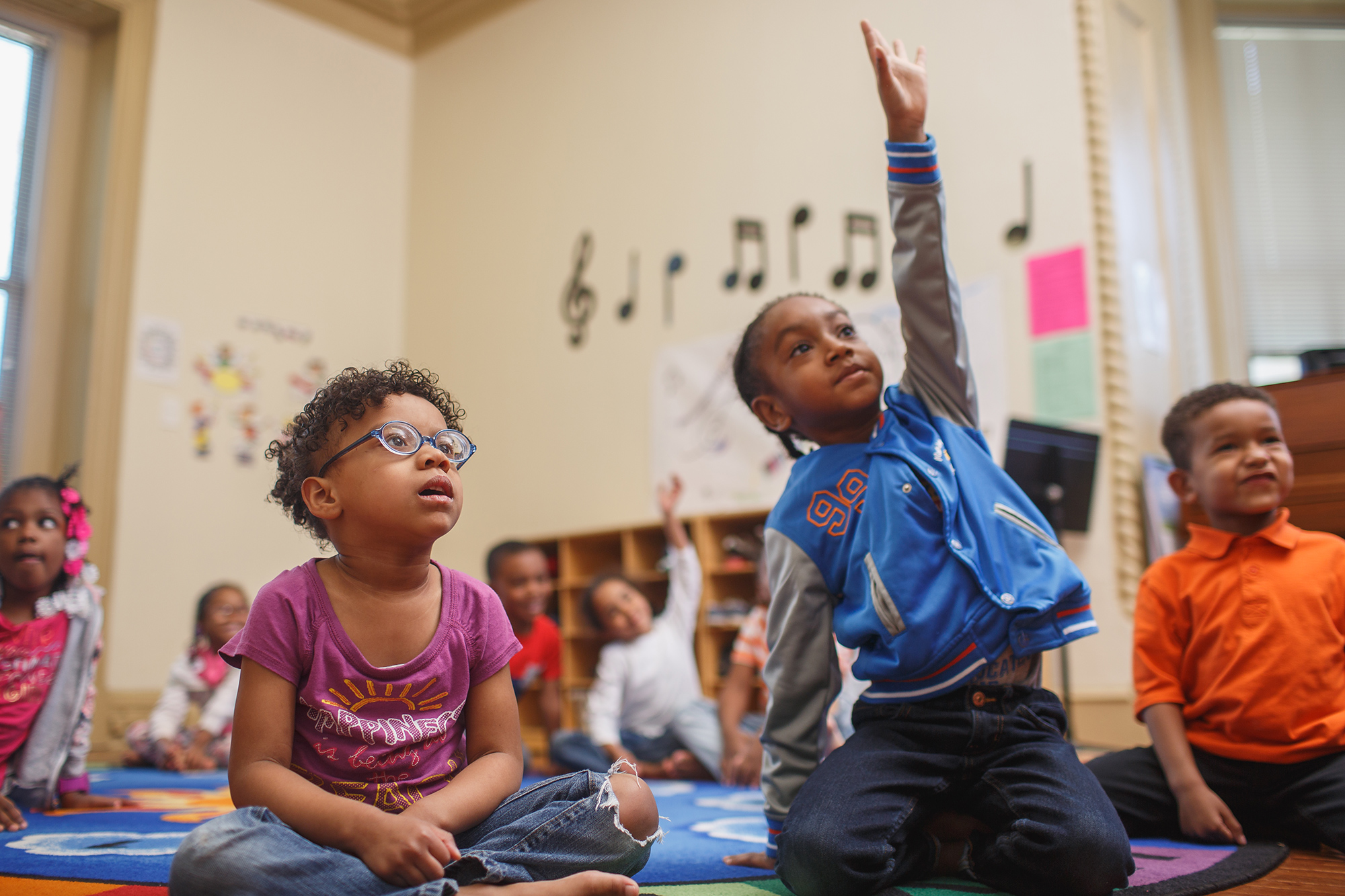 Students raising their hands in a classroom